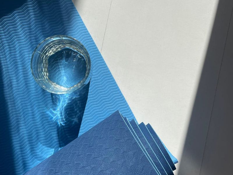 A bright and spacious room with a yoga mat on a wooden floor, ready for practice.