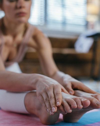 Close-up of a person's hands in a mindful pose on a yoga mat.